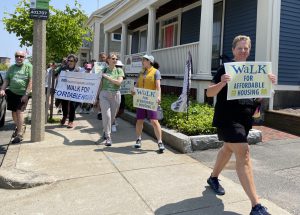 Walkers along sidewalk holding Walk for Affordable Housing signs