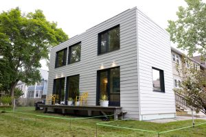 exterior view of 2-story, white accessory dwelling unit with many windows