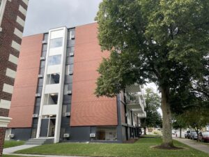 side view of brick building from 1960's with white balconies