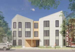 sage and yellow 3 story building with pitched roof