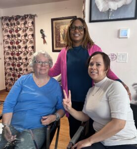 Three women smiling in an apartment